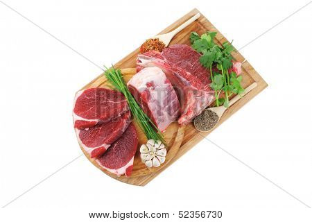 raw meat : fresh beef pork big rib and fillet with garlic and green stuff on wood isolated over white background