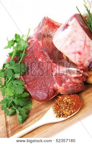 raw meat : fresh beef pork big rib and fillet with garlic and green stuff on wood isolated over white background