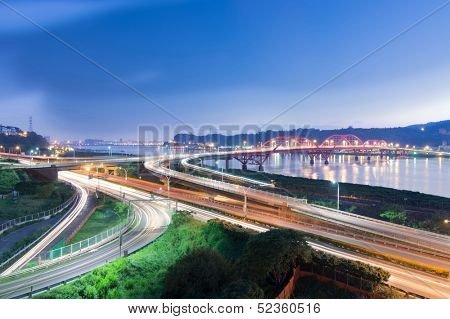 Night scene of cars light at highway and interchange in famous Guandu Bridge, Taipei, Taiwan, Asia.