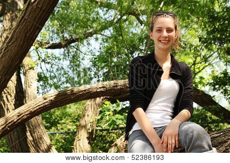 Smiling blonde girl outside in a tree
