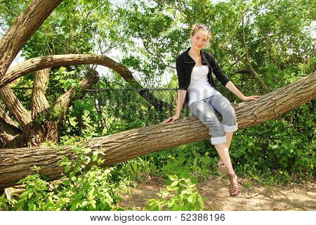 Beautiful blonde teenager si on a huge branch tree