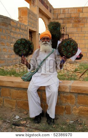 JAILSAMER - INDIA- SEPT 17: Old man sells handmade peacock fans.  World Bank stated, 32% of the total Indian people fall below international poverty line of US$ 1.25 per day on sept 17, 2012 in INDIA