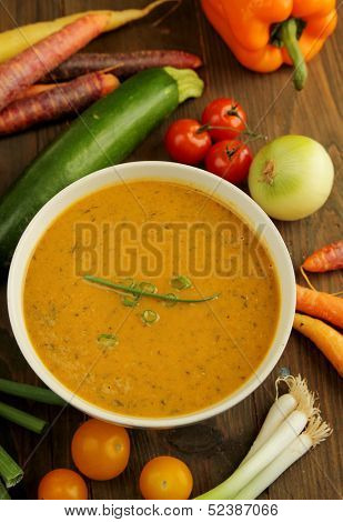 Vegetables soup with fresh vegetables all around the bowl