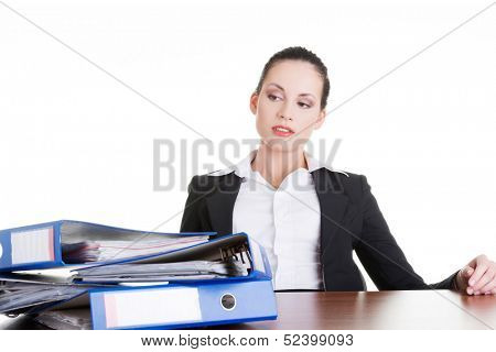 Sad woman with ringbinders sitting at the desk. Tired and exhousted business woman. 