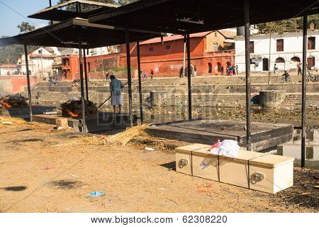 KATHMANDU, NEPAL - DEC 3, 2013: Unidentified local people during the cremation ceremony along the holy Bagmati River in Bhasmeshvar Ghat at Pashupatinath temple in Kathmandu.