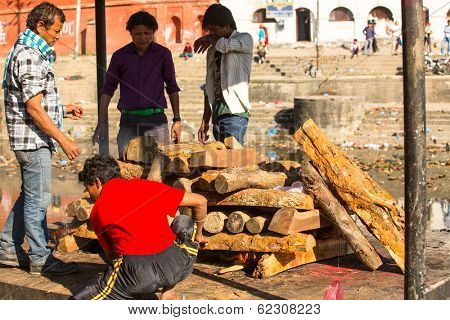 KATHMANDU, NEPAL - DEC 3, 2013: Unidentified local people during the cremation ceremony along the holy Bagmati River in Bhasmeshvar Ghat at Pashupatinath temple in Kathmandu.