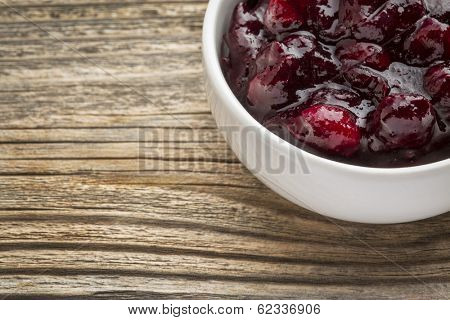 sugar free cranberry sauce with addition of blueberry - side dish bowl against grained wood