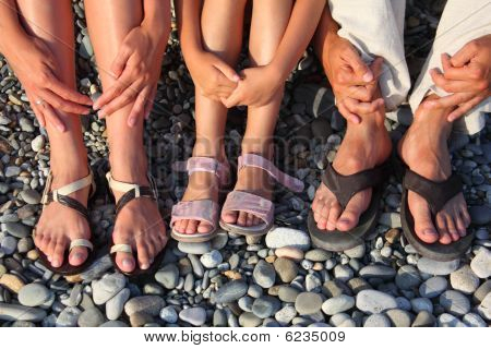 viele Beine und Hände auf den Steinen. Familie mit Mädchen