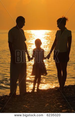drei Silhouetten gegen glossing Meer. Eltern und Tochter.