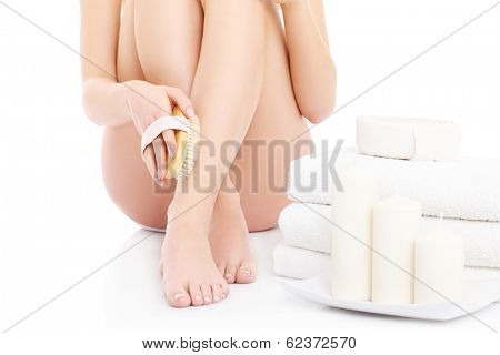 A picture of a woman doing peeling with a brush over white background