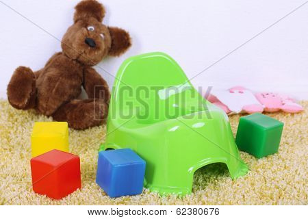 Green potty on home interior background