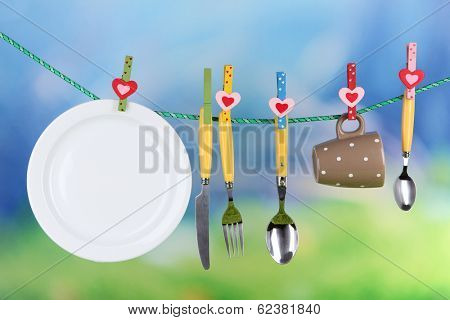 Tableware dried on rope on natural background