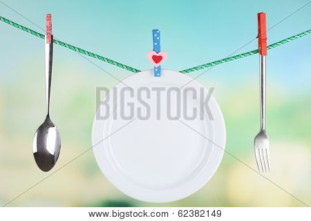 Tableware dried on rope on natural background