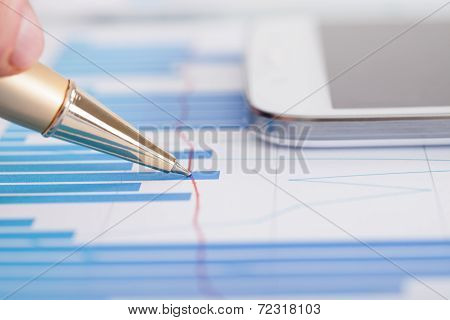 Businessman Analyzing Bargraph At Desk