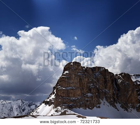 Panorama Of Snowy Rocks And Sky With Sunbeam In Nice Spring Day