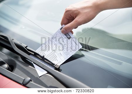 Officer's Hand Putting Parking Ticket On Car