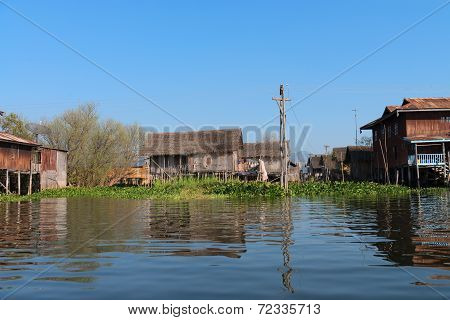 Traditional Stilts House In Water Under Blue Sky