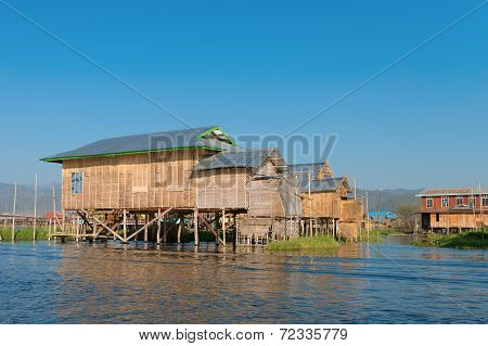 Traditional Stilts House In Water Under Blue Sky