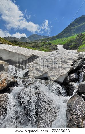Grotto from snow over the mountain river