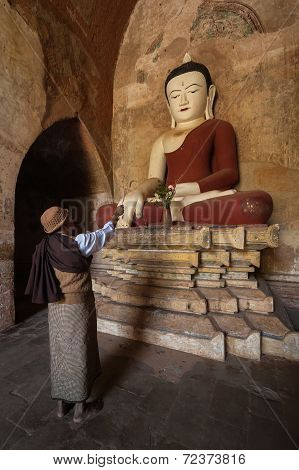 Burmese Man Brings Religious Offerings To Buddha Statue. Bagan, Myanmar (Burma)