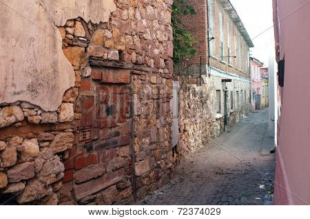 Narrow road between old damaged stone houses