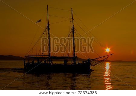 Sailing Into The Sunset With Reflections On The Sea Surface