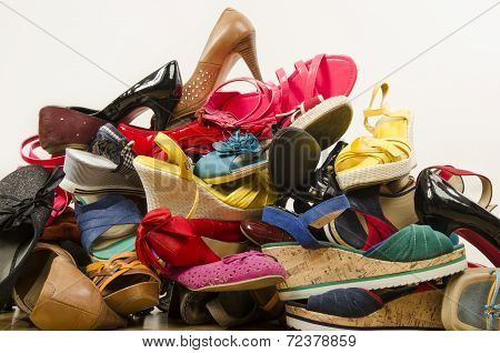 Close up on big pile of colorful woman shoes.