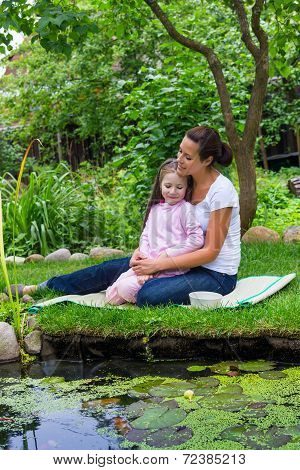 Little Girl With Mum Feeding Fishes