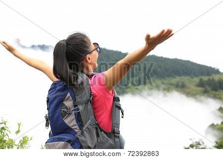 woman hiker open arms at peak of emei mountain ,china