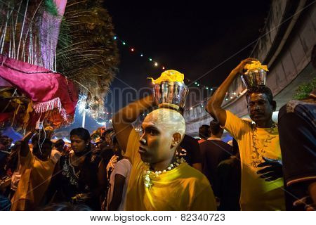 KUALA LUMPUR, MALAYSIA - FEBRUARY 3, 2015: Hindu devotees carry milk pots and kavadis walk in a procession to the Batu Caves temple on Thaipusam day, a day of thanksgiving and devotion.