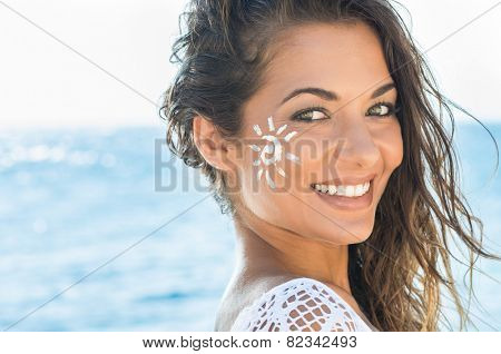 Closeup Of Smiling Young Woman With Suncream On Face At Sea