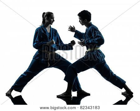 one man woman couple exercising karate vietvodao martial arts in silhouette studio isolated on white background