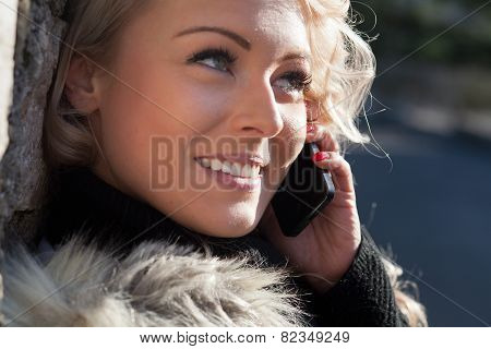 Blonde Woman Talking On Her Mobile Phone Smiling