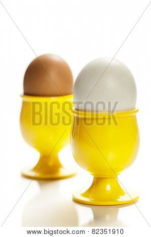 eggs  in yellow eggcups  isolated on white