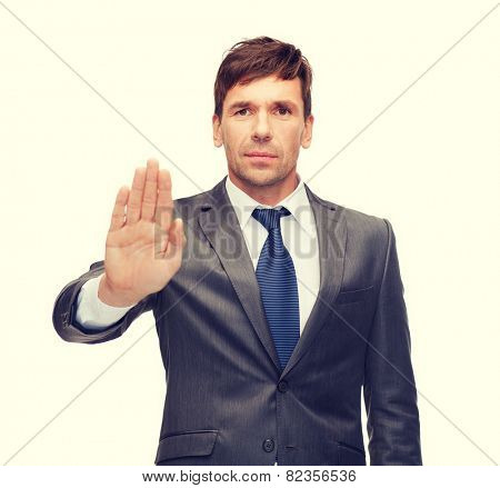 business and office, ban, veto, warning concept - attractive buisnessman making stop gesture