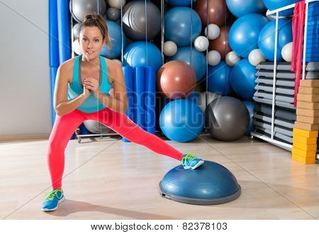 bosu one leg squat girl exercise at gym workout and swiss ball background