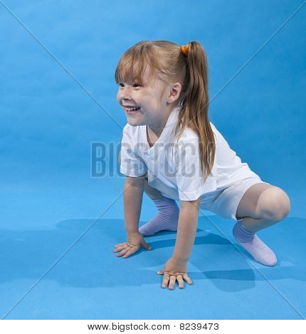 Small Girl Is Posing As Frog On Blue