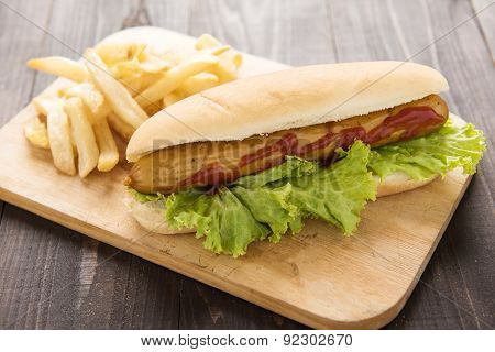 Hot Dog With French Fries On Wooden Background.