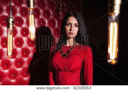 young woman in red dress standing near wall
