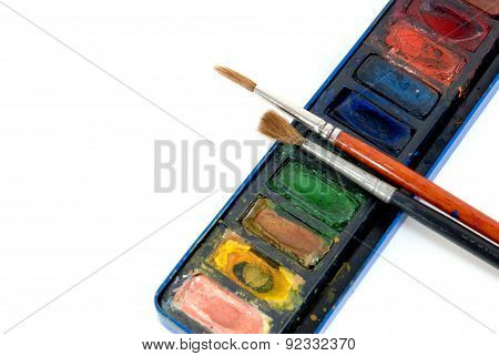 Container of watercolors with brushes