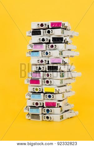 Ink cartridges exhausted stacked on yellow background