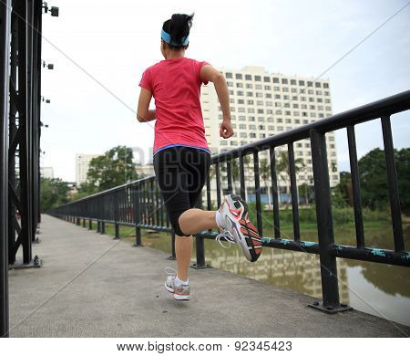 Runner athlete running on iron bridge. woman fitness jogging workout wellness concept.