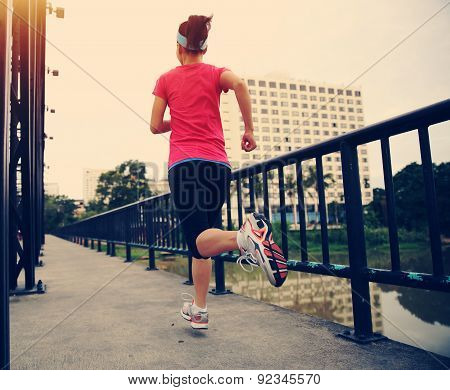 Runner athlete running on iron bridge. woman fitness jogging workout wellness concept.