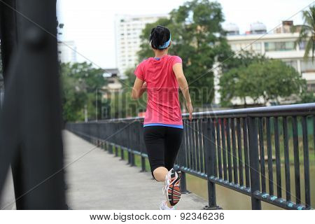 Runner athlete running on iron bridge. woman fitness jogging workout wellness concept.