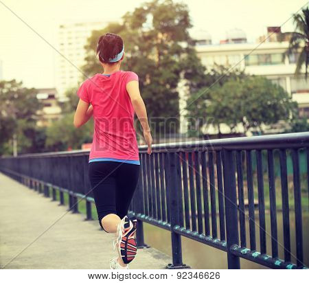 Runner athlete running on iron bridge. woman fitness jogging workout wellness concept.
