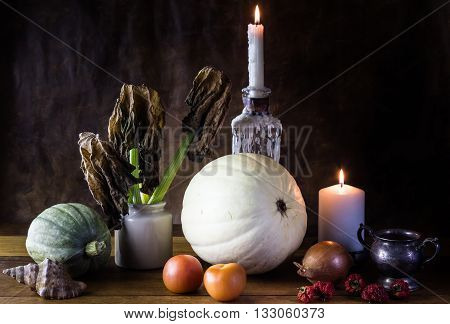 Vanitas style pumpkin vegetables and candles still life