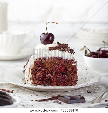 Black forest cake decorated with whipped cream and cherries Schwarzwald pie dark chocolate and cherry dessert on a white wooden background