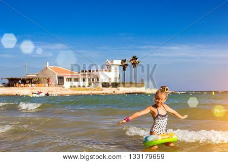 Cute Girl In Swimsuit Bathes On Waves In Sea. Sunny Mediterranean Beach, Cala Del Palangre, Torrevie