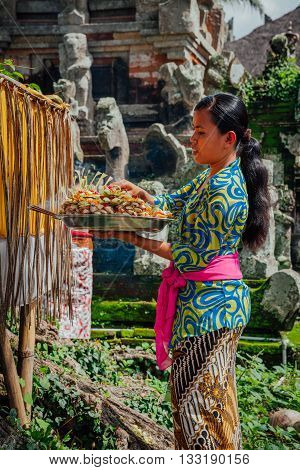 UBUD, INDONESIA - MARCH 01: Balinese woman in traditional clothes making offerings in the temple Ubud Bali Indonesia on March 01 2016