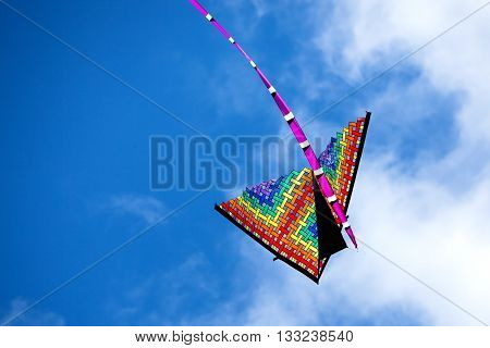 colorful kite flying up in blue sky